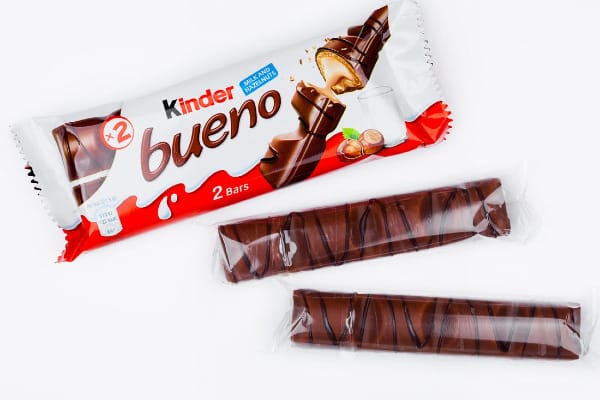 Kinder Bueno wrapper with two pieces of kinder bueno individually wrapped in plastic.