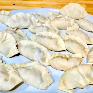 A plate of uncooked dumplings.